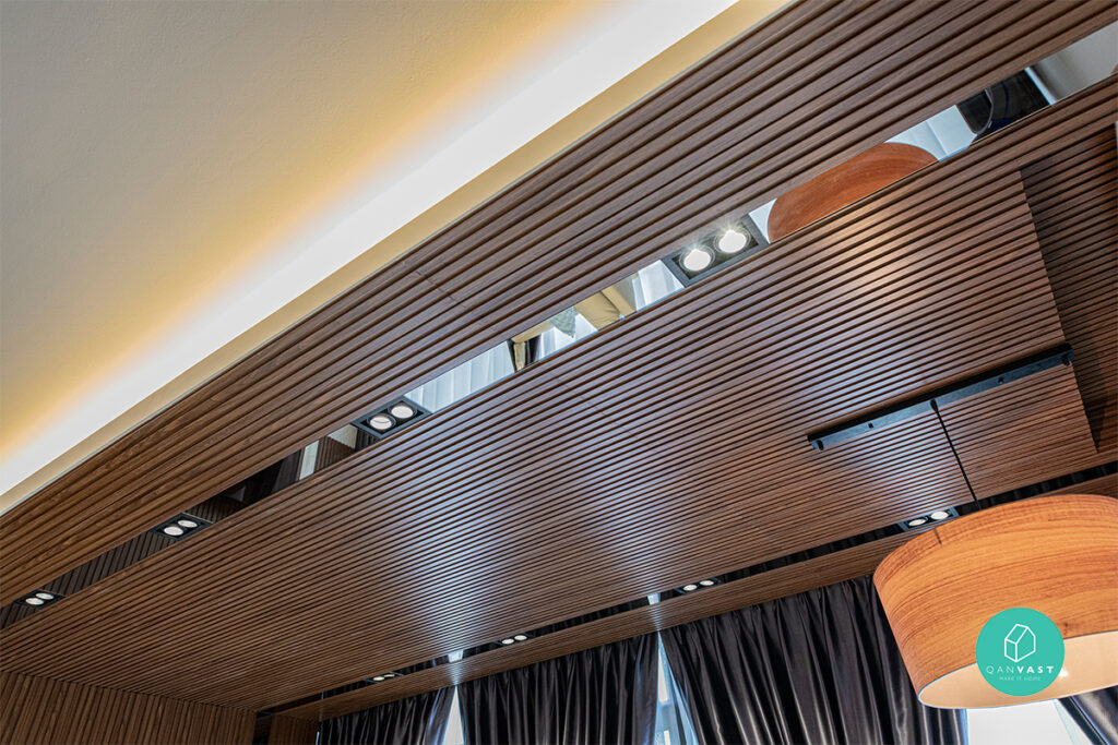 Elegant ceiling design featuring rich brown wood beams, a reflective mirror accent, and warm orange lamps, creating a cozy and inviting atmosphere in the living space.
