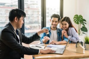 two people happy receiving key to house from owner