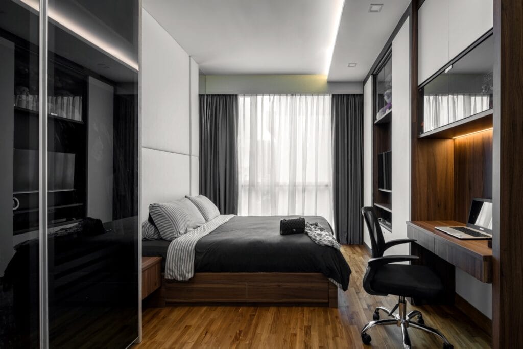 Master bedroom at Sennett Residence with upholstered headboard wall, walnut veneer study nook, sheer and blackout double curtains, and timber flooring The master bedroom pairs an upholstered headboard wall with a built-in walnut study nook — restraint over decoration.