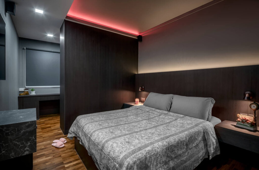 Dark-themed HDB master bedroom with wood headboard feature wall, cove lighting and walk-in vanity at 776 Pasir Ris