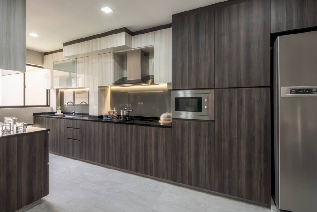 Galley kitchen with dark walnut laminate cabinetry, black quartz worktop and built-in appliances in a 5-room HDB