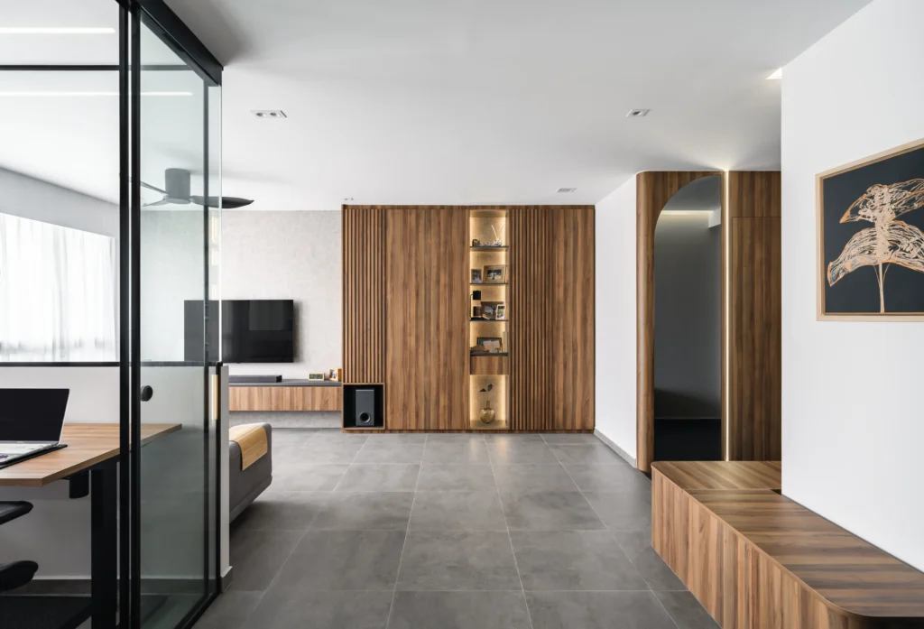 Scandinavian living room with sectional sofa, TV unit, glass-enclosed workspace, large windows with sheer curtains, and LED-lit cabinetry.