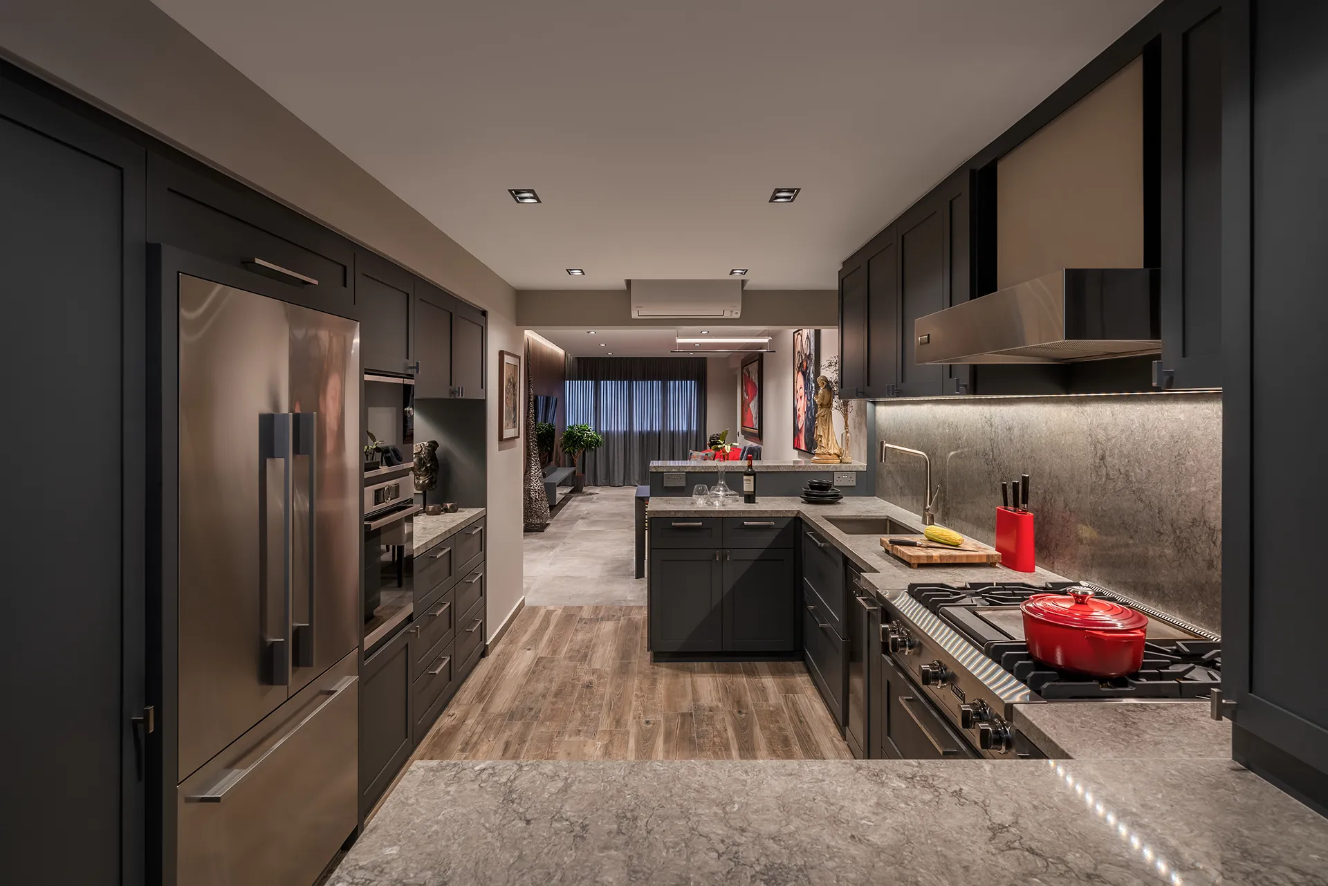 Open-concept kitchen and living area in a Bukit Purmei HDB, with dark cabinetry, stainless steel appliances, and a red Dutch oven.
