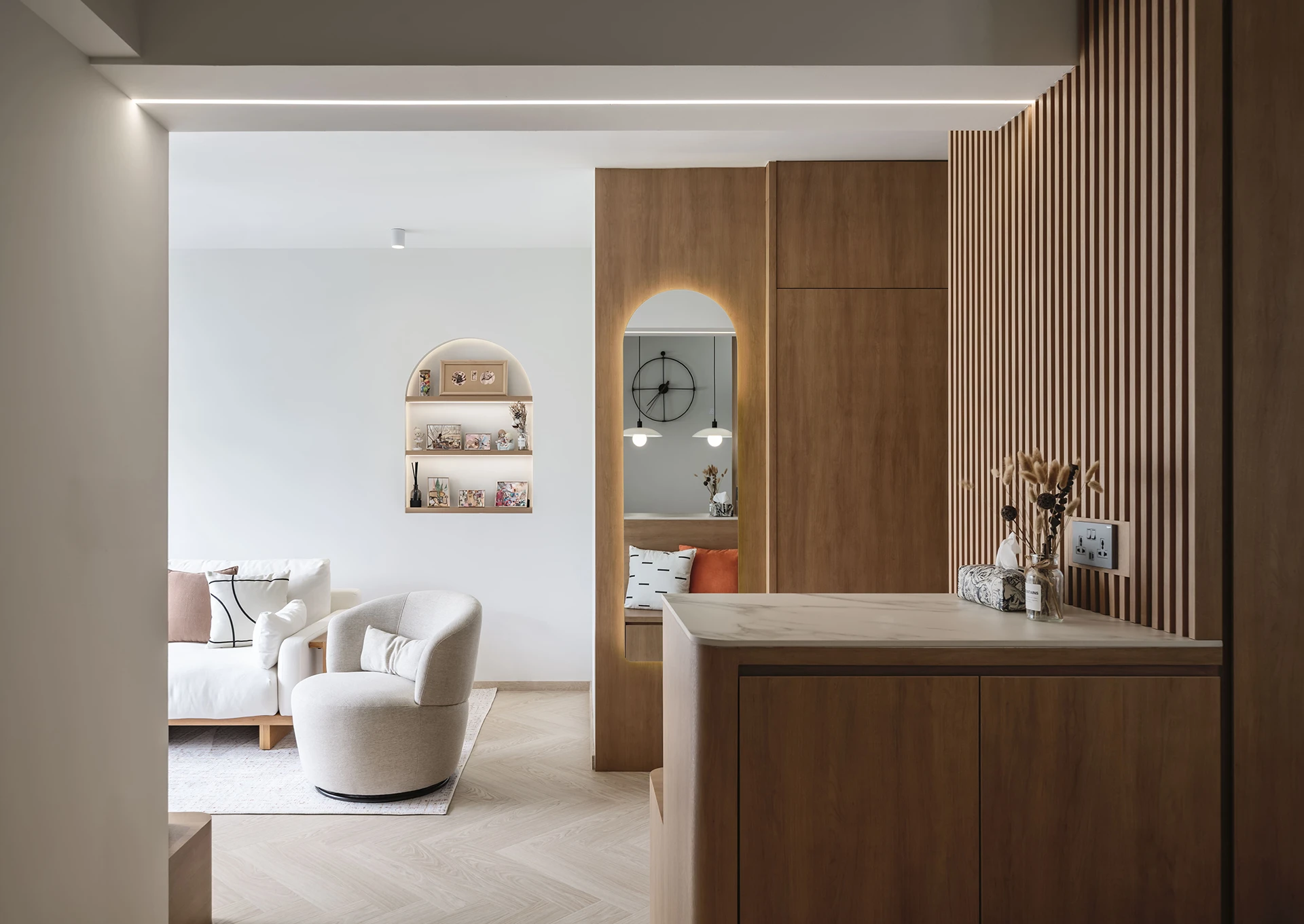 Wood slat divider with built-in display nook featuring round wall clock and dried florals in a modern HDB kitchen design