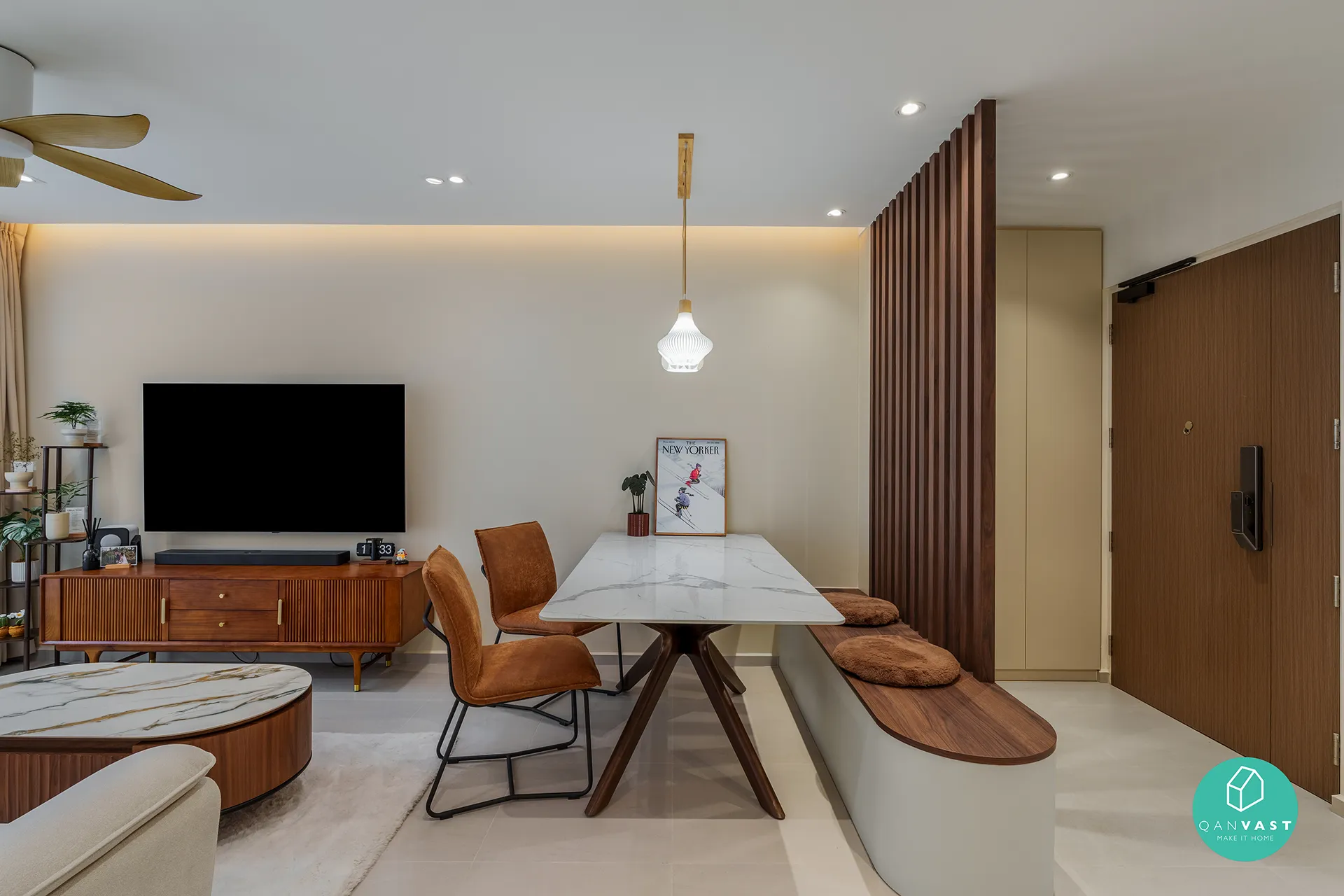 Modern dining area with a marble table and burnt orange chairs, visually divided from the entrance by a wooden slat partition.