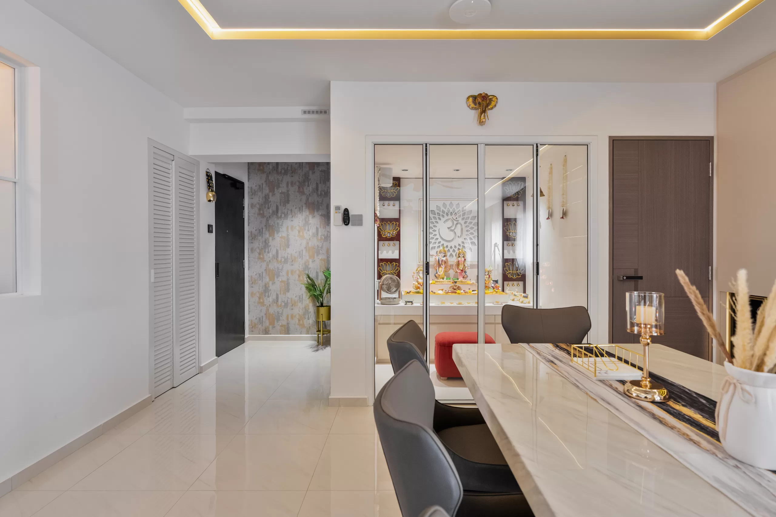 609 Elias Road, 5-room HDB, Modern Luxury dining room. Integrated glass-enclosed altar space with religious 'Om' symbol, mirrored panels, and marble dining table.