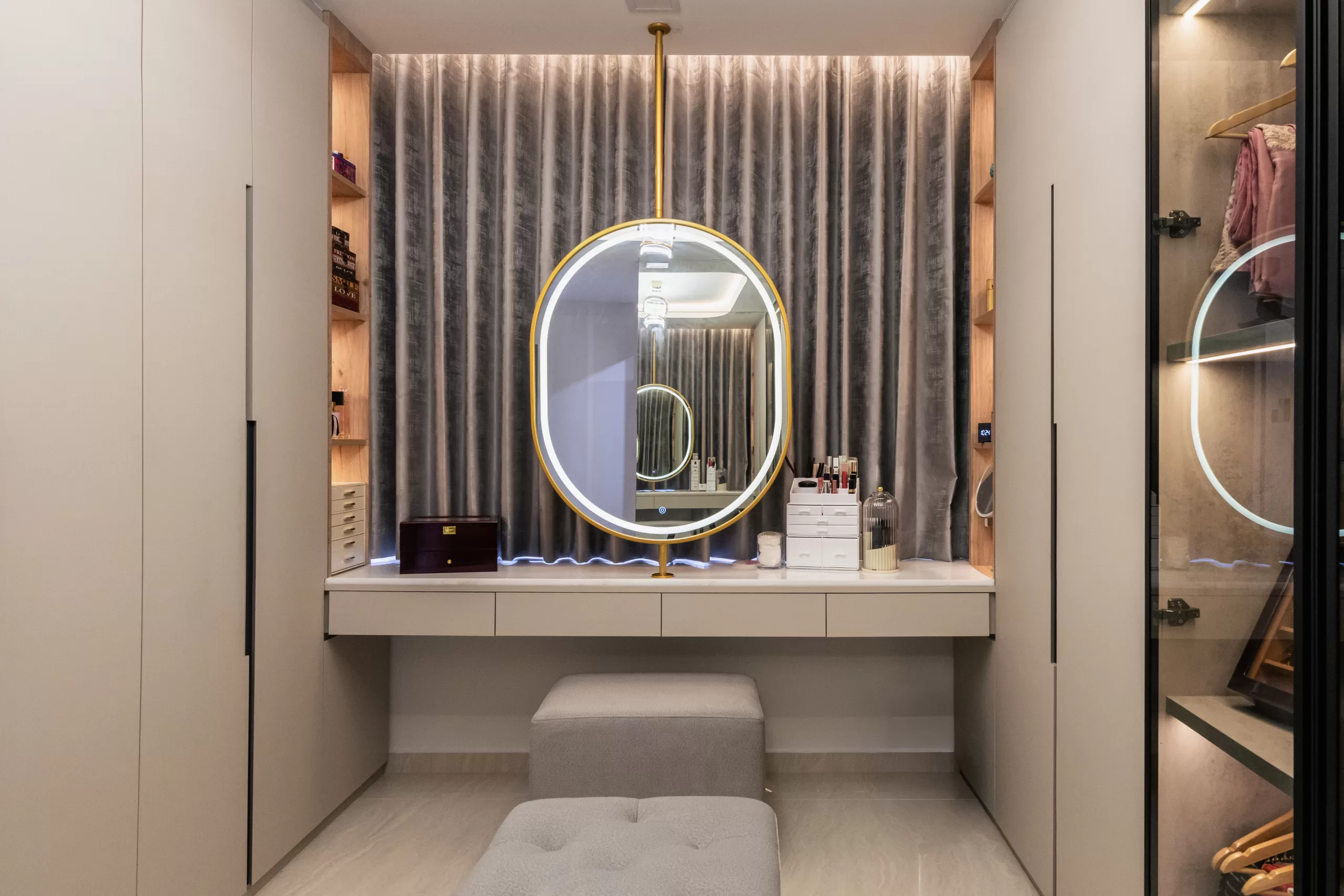 609 Elias Road, 5-room HDB, Modern Luxury dressing room. Vanity area with suspended circular gold-frame mirror, illuminated built-in shelves, and upholstered ottomans.