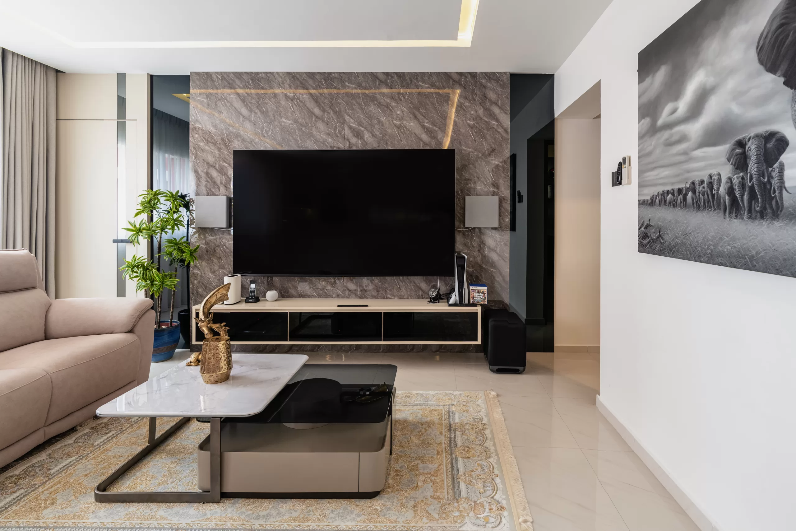 609 Elias Road, 5-room HDB, Modern Luxury living room. Textured stone media wall with subtle gold accents, minimalist TV console, and elephant wall art.