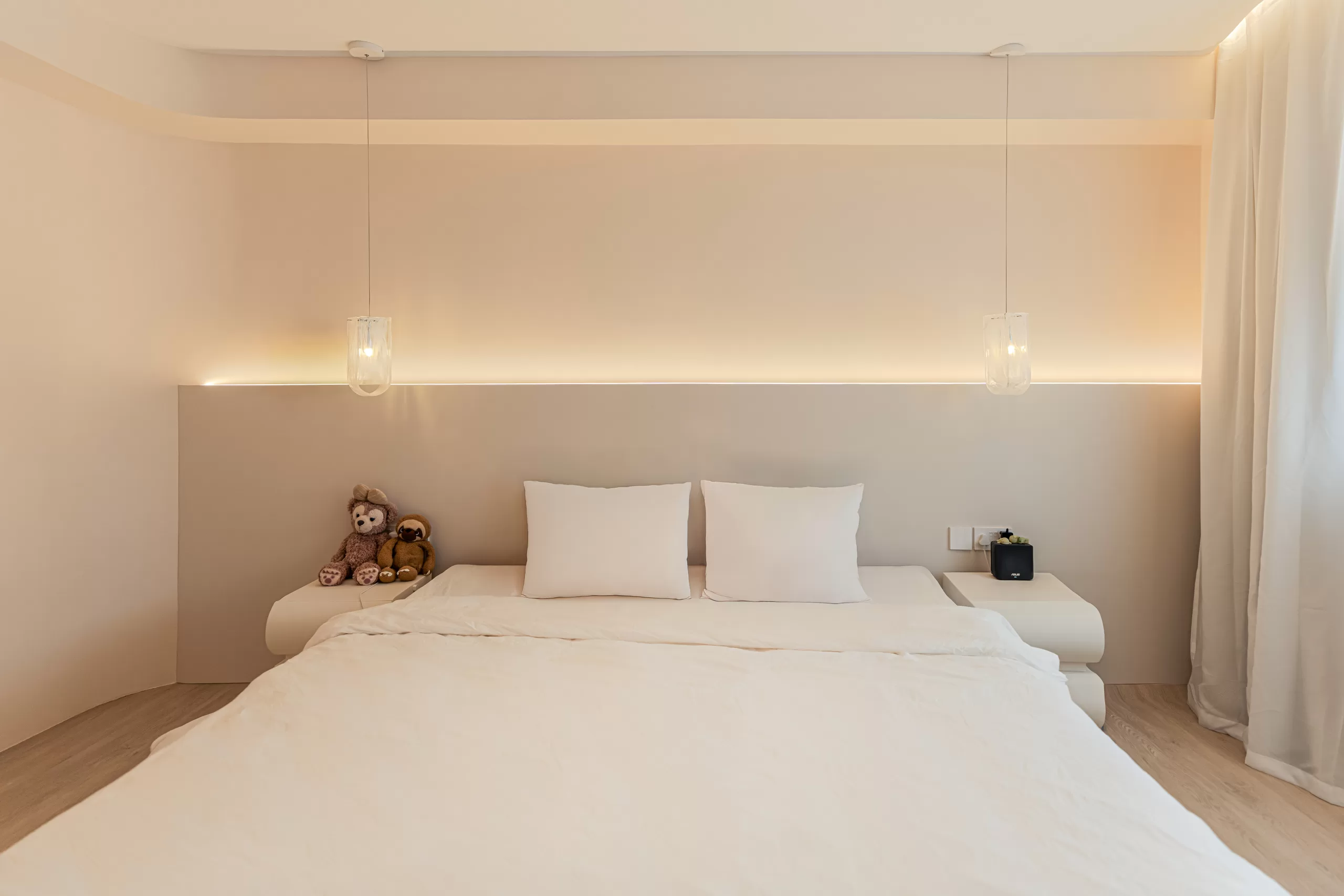 Wabi-Sabi minimalist master bedroom showcasing symmetrical design, recessed warm ambient lighting behind the bed, and plush textures for a tranquil retreat.