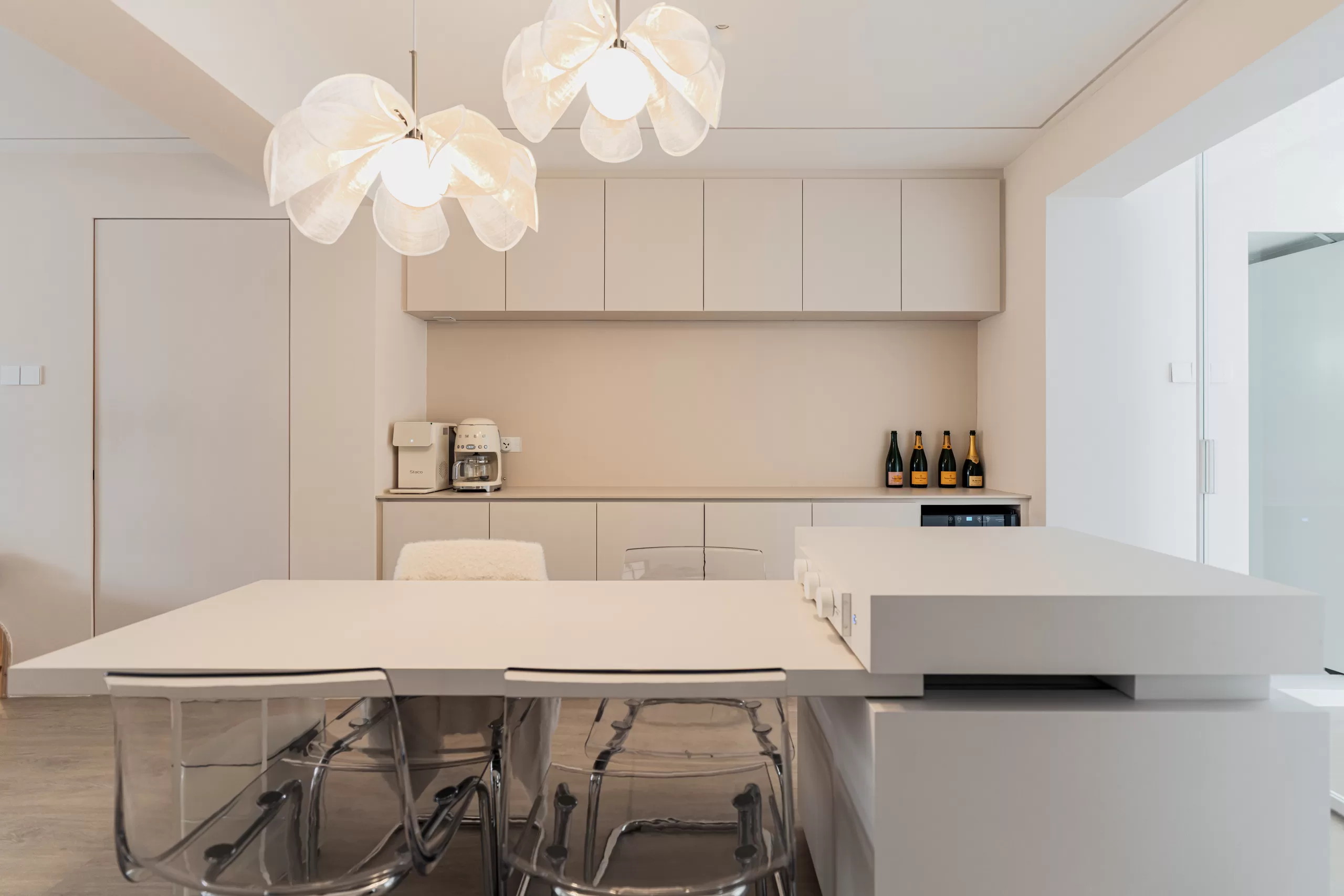 Wabi-Sabi minimalist dining area in 4-room HDB at Jalan Bukit Merah with soft beige cabinetry, white table, and transparent acrylic chairs.