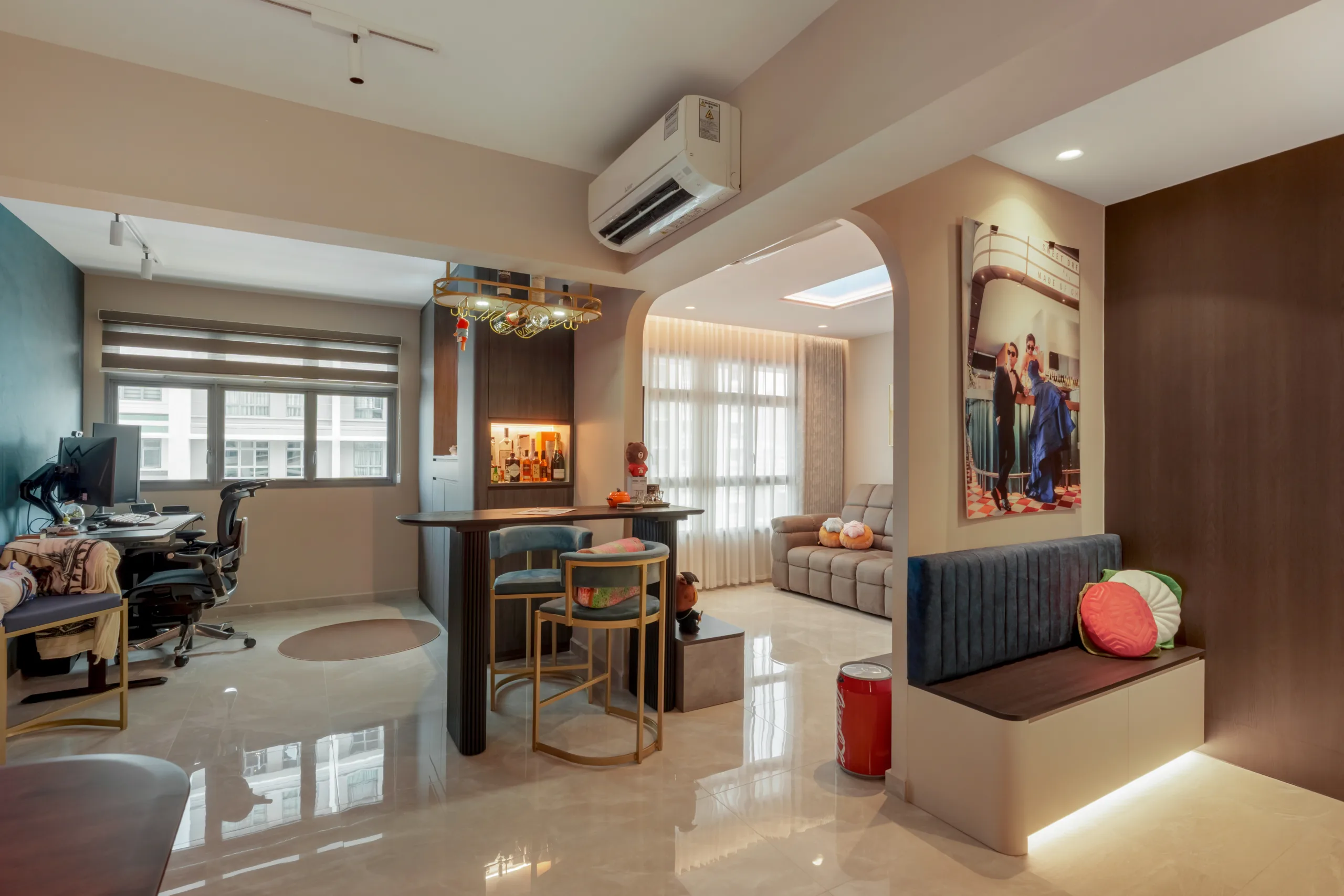 Multifunctional living space showing a transition from a dark wood bar counter to a bright lounge area with an archway.