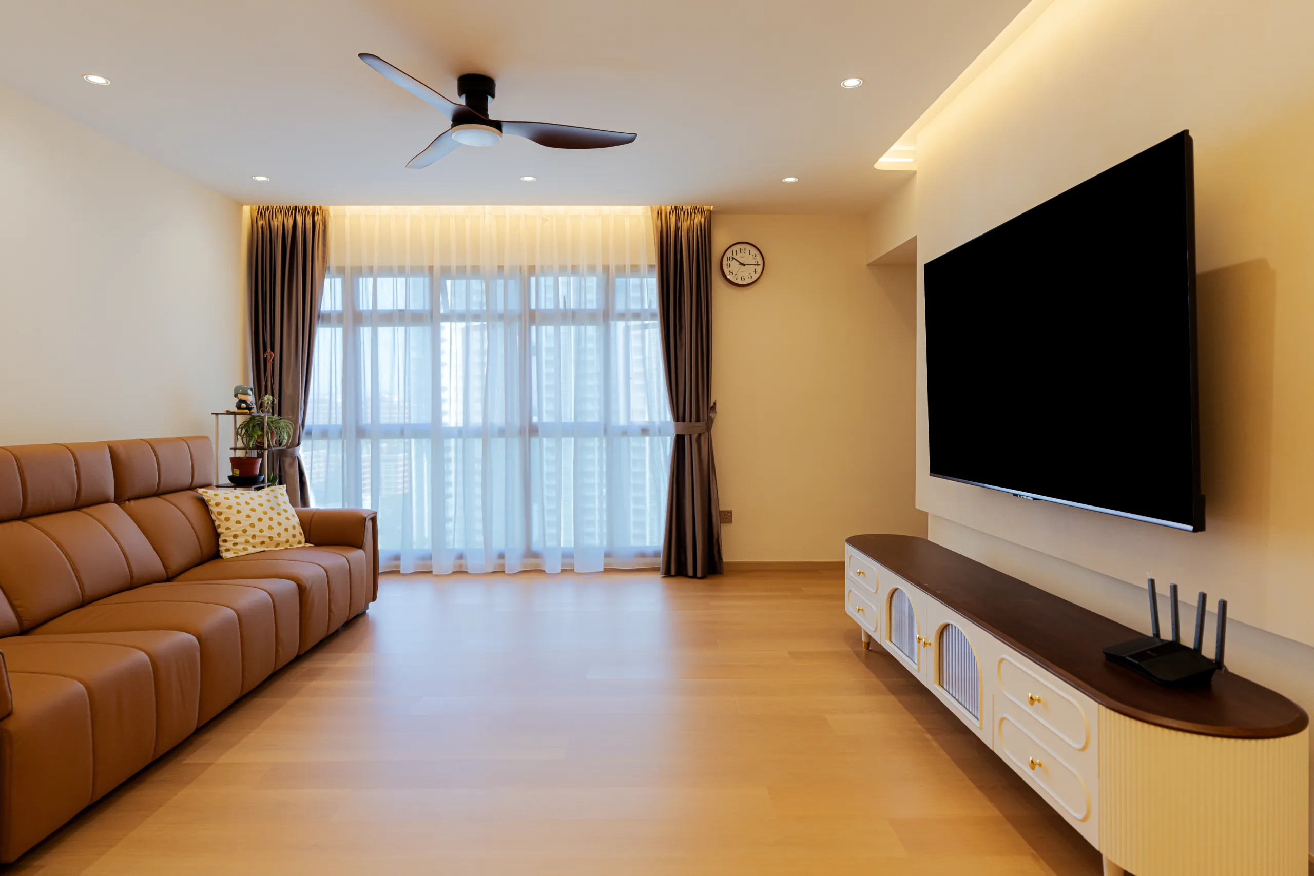 Spacious living room at 75B Redhill Road with a brown leather sectional sofa and layered sheer white curtains.