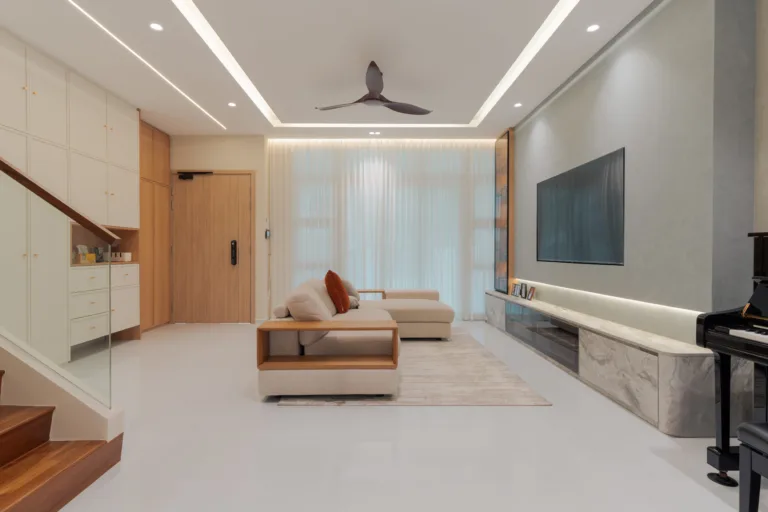 Spacious landed house living room with L-shaped sofa, marble TV feature wall, ceiling fan, and sheer curtains in Jalan Redop home by Zenith Arc Singapore