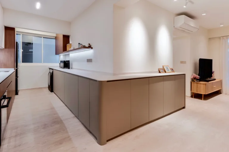 Long taupe storage island dividing the dry kitchen and living area in a 3-room HDB