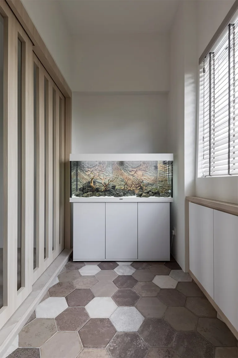 Aquarium nook with patchwork hexagon floor tiles and oak-framed glass partition