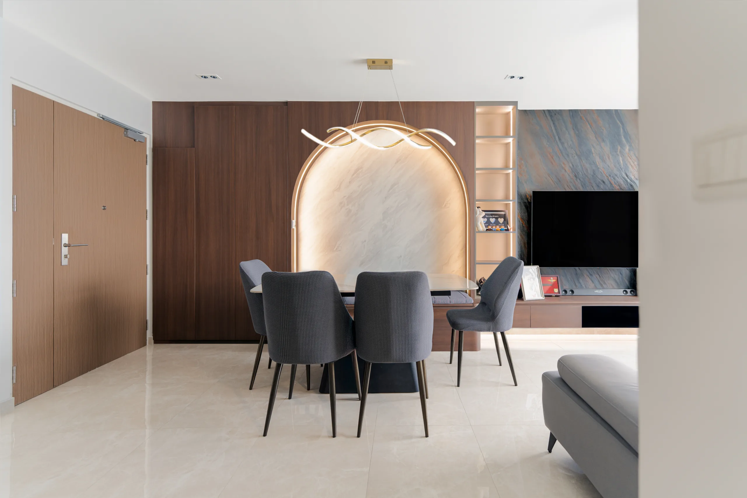Modern contemporary dining area with backlit arch feature wall and walnut joinery at a 4-room BTO in Toa Payoh East