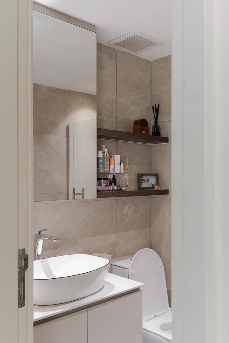 Modern contemporary bathroom with beige marble-look tiles, countertop basin and floating timber shelves