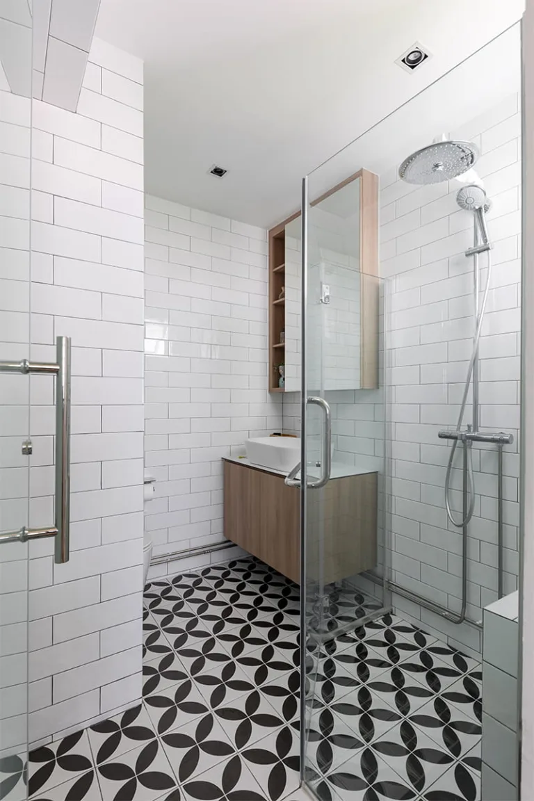 Wet-and-dry HDB bathroom with subway tiles, floating oak vanity and black-and-white patterned floor