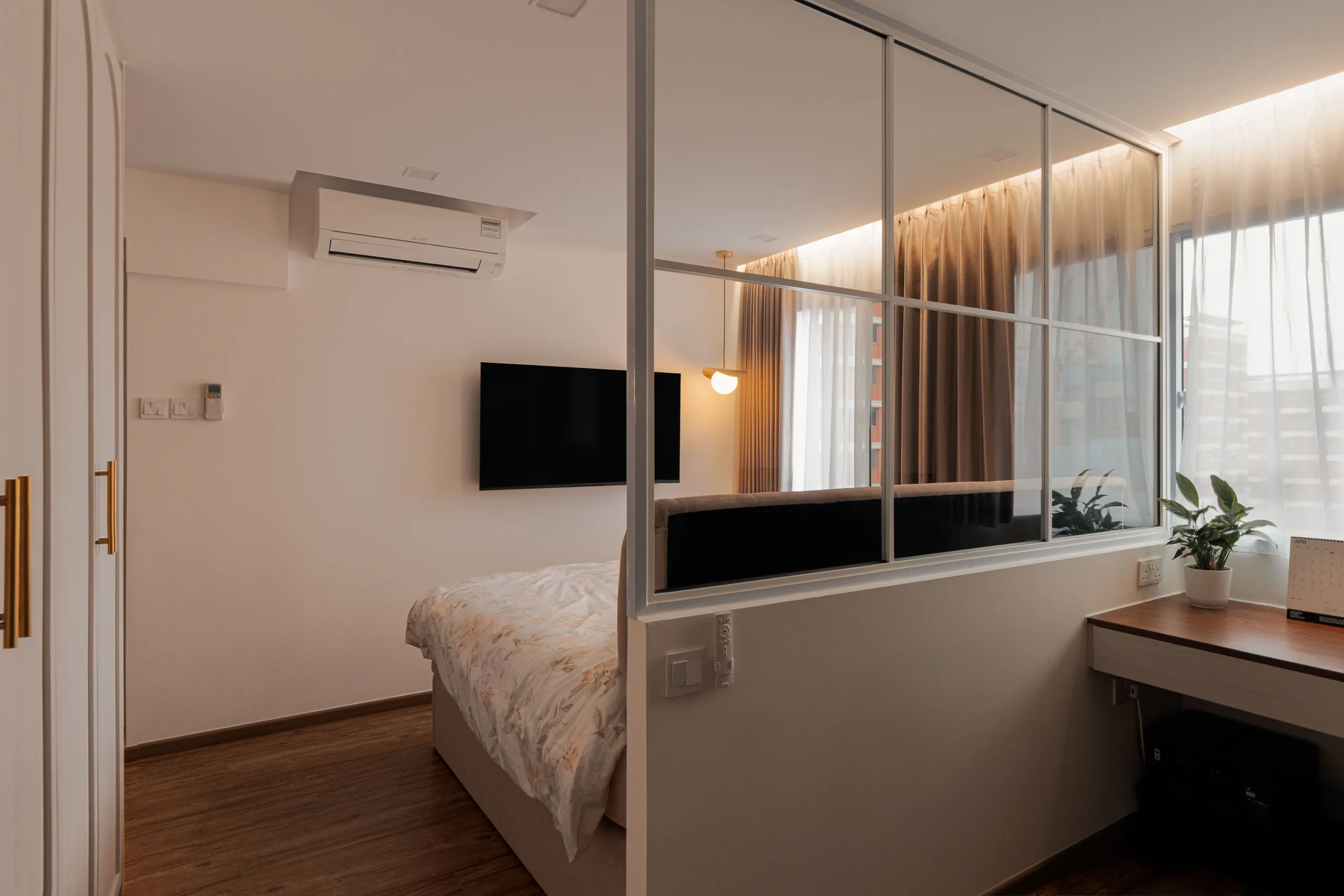 Bedroom with an internal glazed partition separating a desk nook at the window