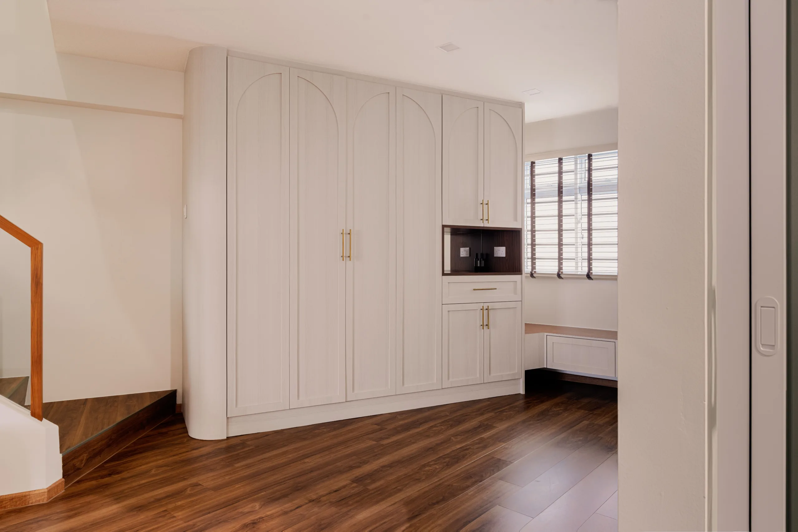 Arched shaker wardrobe wall with brass pulls in a modern farmhouse HDB maisonette entryway