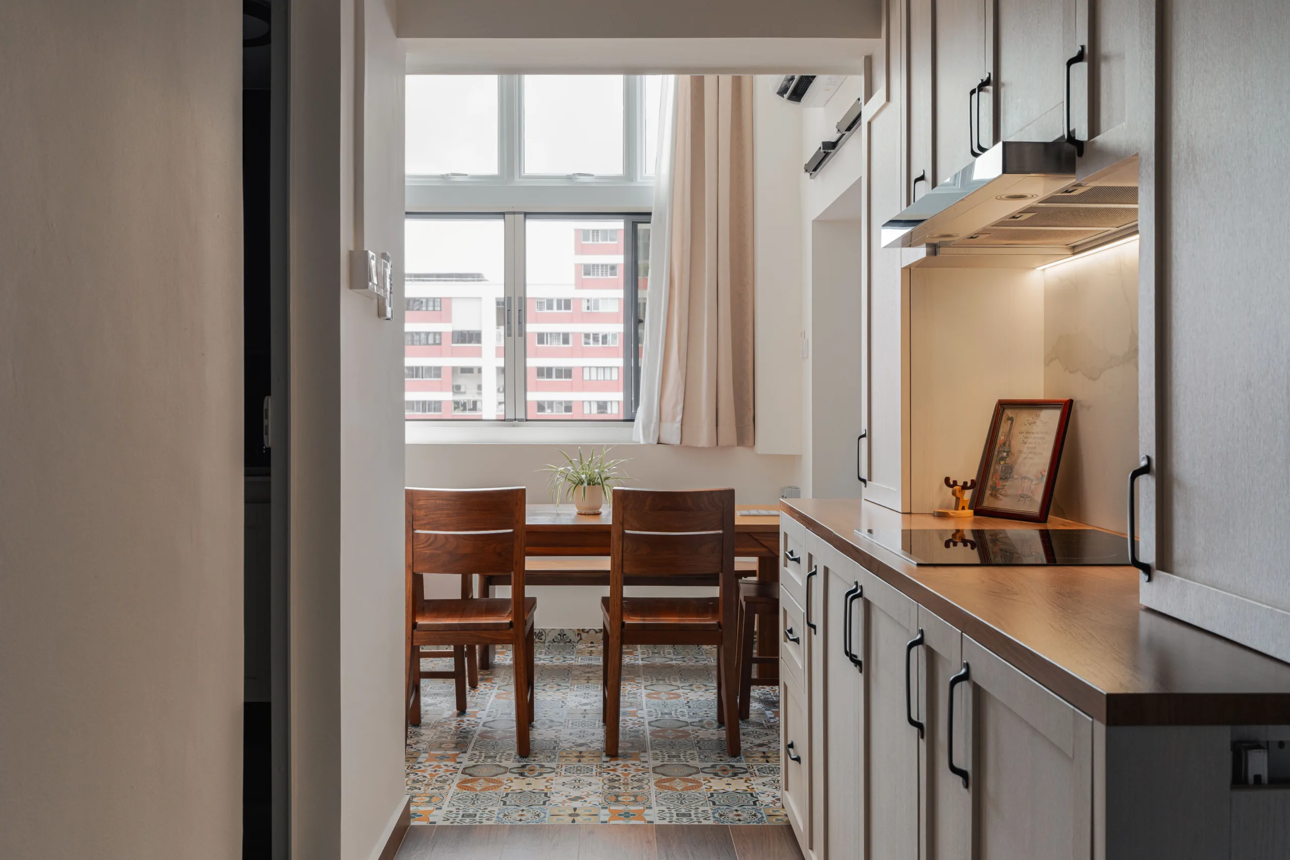 Galley kitchen with wood-tone worktop and matt black handles opening to the dining room